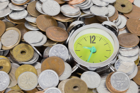 Japanese coins arranged against the clock.の写真素材