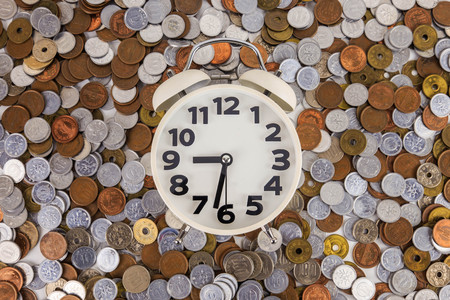 Japanese coins arranged against the clock.の写真素材