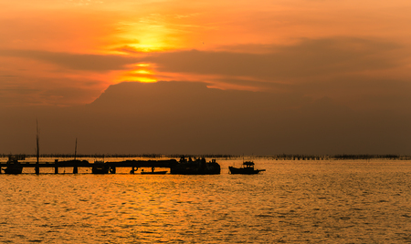 Ship port piers and big red sun on colorful skyの写真素材