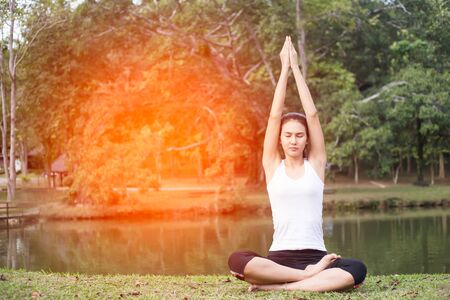 Young woman doing yoga in morning parkの写真素材