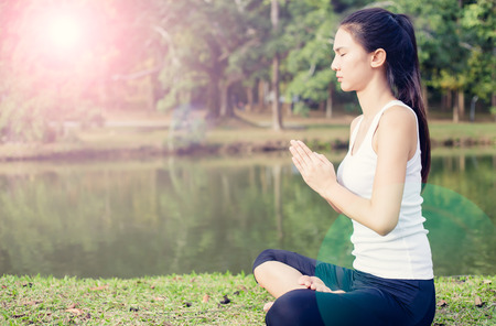 Young woman doing yoga in morning parkの写真素材