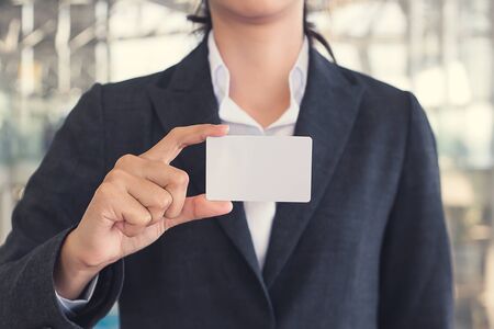 Young woman in international airport, checking her phone while waiting for her flight and Happy smiling young business woman hand holding blank card isolated with white backgroundの写真素材