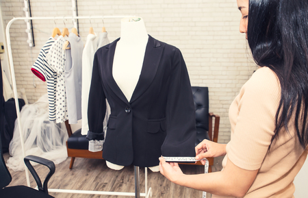 Fashion designer measuring a dress. Shallow depth of field.
Young woman choosing clothes and measure clothes on a puppetsの写真素材