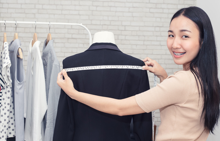 Fashion designer measuring a dress. Shallow depth of field.
Young woman choosing clothes and measure clothes on a puppetsの写真素材