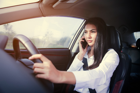 Beautiful Business woman sitting on car seat and fastening seat belt, car safety concept.の写真素材