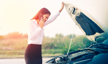 Beautiful Business woman upset because of car crash.の写真素材