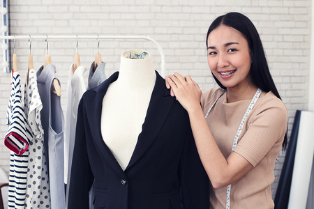 Fashion designer measuring a dress. Shallow depth of field.
Young woman choosing clothes and measure clothes on a puppetsの写真素材
