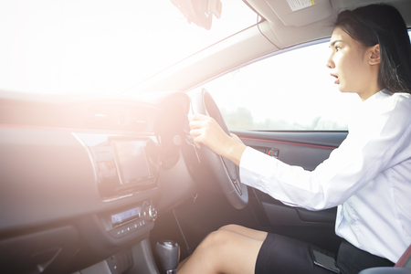 Beautiful Business woman sitting on car seat and fastening seat belt, car safety concept.の写真素材