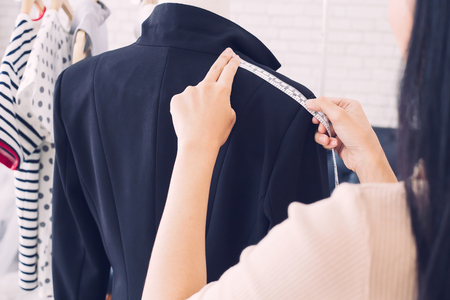 Fashion designer measuring a dress. Shallow depth of field.
Young woman choosing clothes and measure clothes on a puppetsの写真素材