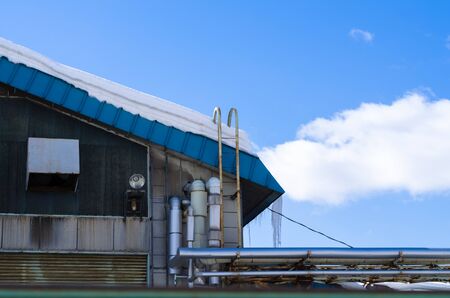Roof icicles, blue skyの写真素材