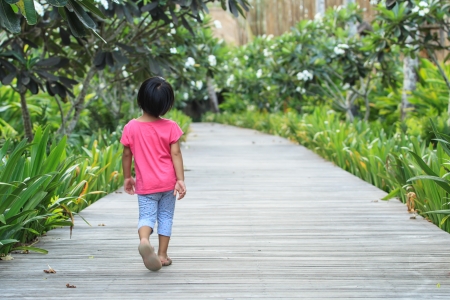 A rear view of toddler girl walking straight by her ownの写真素材