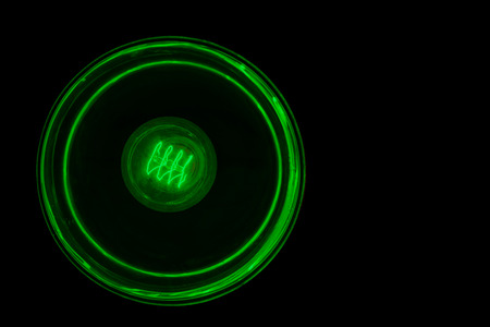 Light bulb illuminated isolated against blackの写真素材