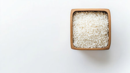 Rice grains in a square-shaped container, top view with white background and copy space for product labelsの素材