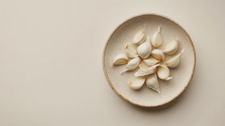 Minimalist top view of garlic on a plate, clean white background with room for text or brandingの素材