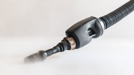 A close-up view of a fuel pump nozzle showcasing its design and functionality. The sleek black material and metallic connection highlight modern fueling technology in the automotive industry.の素材