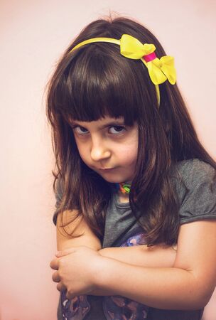 Angry child girl portrait at home in soft tones