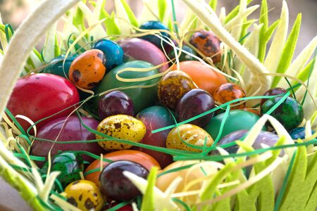 Multicolored painted Easter eggs in hand basketの写真素材