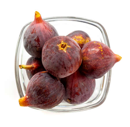 Ripe figs in glass cup over white backgroundの写真素材
