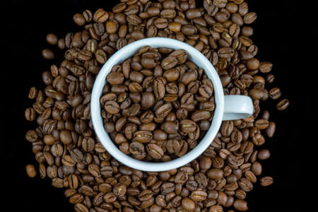 White cup arranged with coffee beans isolated on black backgroundの写真素材