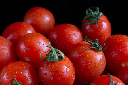 Cherry tomatoes on black backgroundの写真素材