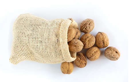 Walnuts in a sack on white backgroundの写真素材
