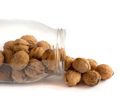 Whole solid walnuts in a jar on white backgroundの写真素材