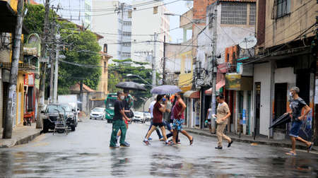 salvador, bahia, brazil - january 8, 2021: people using umbrella during rain in downtown Salvador.