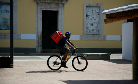salvador, bahia, brazil - december 28, 2020: food delivery man using the Uber eats app is seen walking down the street in the Comercio neighborhood, in the city of Salvador.のeditorial素材