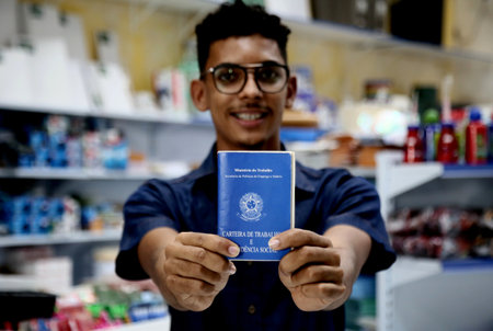 mata de sao joao, bahia, brazil - october 1, 2020: young man of black ethnicity displays a work and social security card, a necessary document for formalizing the registration of work in Brazil.のeditorial素材