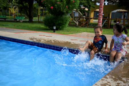 salvador, bahia / brazil - agust 11, 2019: child is seen playing with water at the edge of the pool in the city of Salvador. *** Local Caption ***のeditorial素材