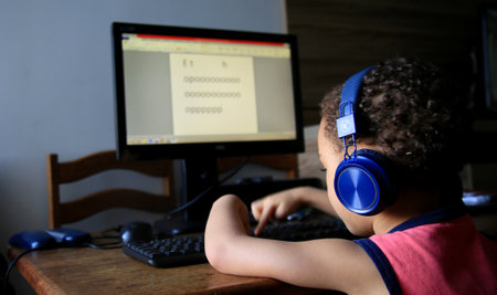salvador, bahia / brazil - june 17, 2020: child is seen wearing a wireless headset while using a...