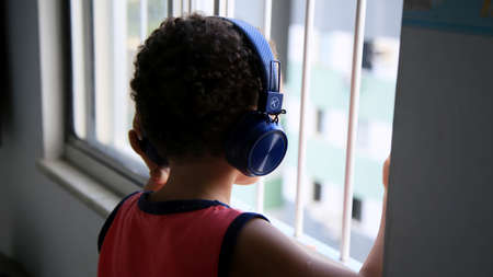 salvador, bahia / brazil - june 17, 2020: child is seen wearing a wireless headset while watching...