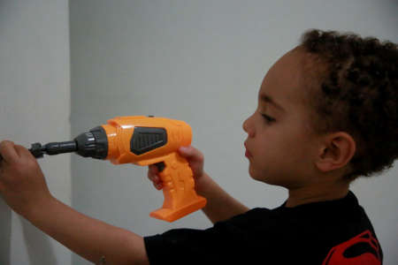 salvador, bahia / brazil - september 28, 2019: child is seen playing with drilling machine.のeditorial素材