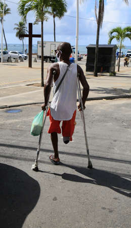 salvador, bahia, brazil - february 4, 2021: man with amputated leg using crutches in the Itapua...