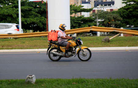 salvador, bahia, brazil - december 18, 2020: delivery of food by application is seen using a motorcycle in the Pituba neighborhood, in the city of Salvador.のeditorial素材