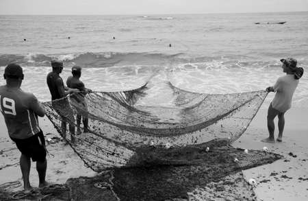 salvador, bahia, brazil - december 18, 2020: fishermen are seen during fishing with a trawl along the fishing colony on Pituba beach, in the city of Salvador.のeditorial素材
