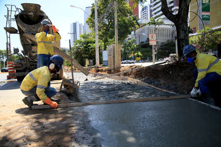 salvador, bahia, brazil - december 9, 2020: masons work on the construction of a concrete floor in...