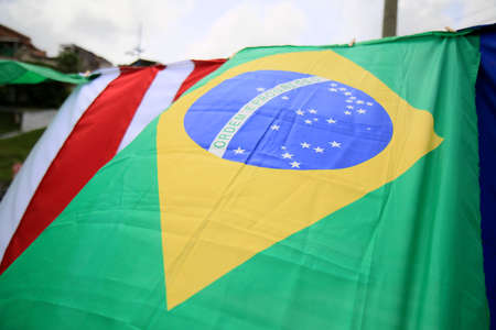 flag of brazil is seen next to a shack in the Itapua neighborhood in the city of Salvador.の写真素材
