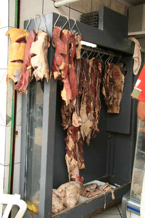 salvador, bahia / brazil - may 11, 2013: a person is seen joining the bolvina meat for sale in a butcher shop at Feira de Sao Joaquim in the city of Salvador.のeditorial素材