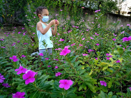 salvador, bahia / brazil - november 24, 2020: child is seen playing in a flower garden in the city of Salvador.のeditorial素材