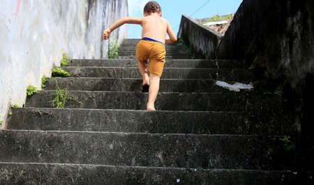 salvador, bahia / brazil - july 2, 2020: child is seen climbing stairs in residential condominium in...