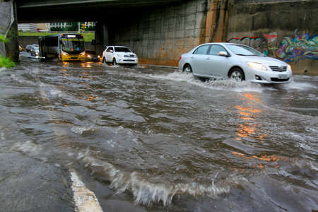 salvador, bahia / brazil - november 28, 2013: vehicles transit through flooding of the road in the...