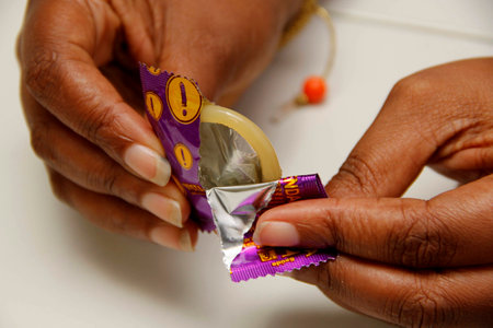 salvador, bahia / brazil - february 6, 2013: hand holds male condom, contraceptive method and also...