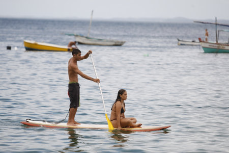 salvador, bahia / brazil - february 21, 2016: People are seen practicing stand up pedal on the beach of Porto da Barra, during the summer of the city of Salvador.のeditorial素材