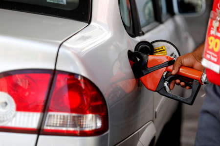 salvador, bahia / brazil - august 20, 2019: gas station attendant is seen fueling a vehicle at a gas station in the city of Salvador.のeditorial素材