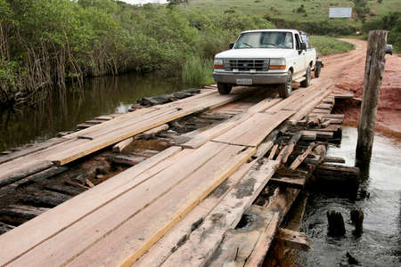 prado, bahia / brazil - july 7, 2009: vehicle is seen crossing wooden bridge over a dirt road in the rural area of the city of Prado, in southern Bahia.のeditorial素材