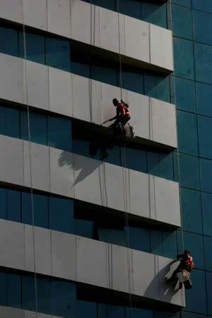 salvador, bahia / brazil - july 8, 2016: man is seen hanging from a building during painting work in the Pituba neighborhood, in the city of Salvador.のeditorial素材