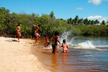 santa cruz cabralia, bahia / brazil - july 26, 2008: people play in the water of the Guaiu River in the Santo Andre district in Santa Cruz Cabralia.のeditorial素材