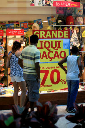salvador, bahia / brazil - march 7, 2014: Customers are seen near the shop window with promotion...