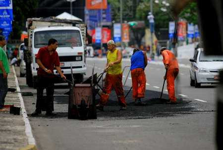 salvador, bahia / brazil - december 29, 2013: Officials make asphalt replenishment in hole in the road in Salvador city, in operation known as slap hole.のeditorial素材